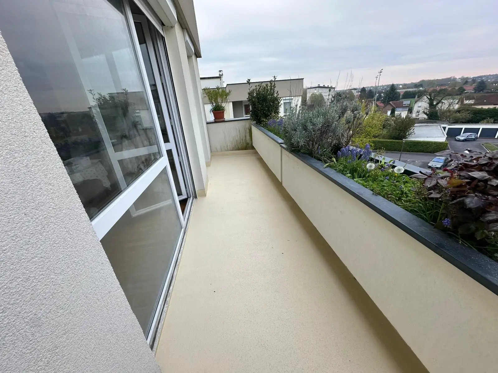Balcon d'appartement rénové en résine claire, prêt à être remis en service
