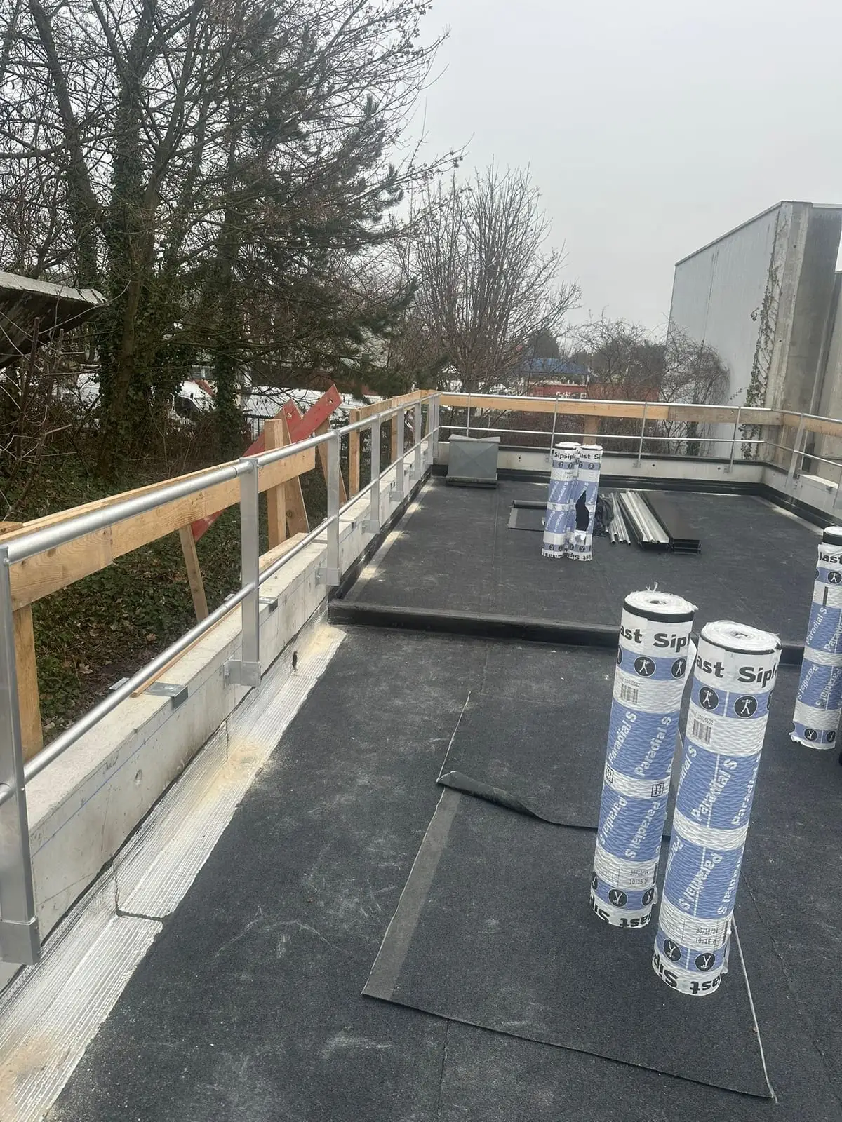Rouleaux de membrane bitumineuse en attente de pose sur un chantier neuf