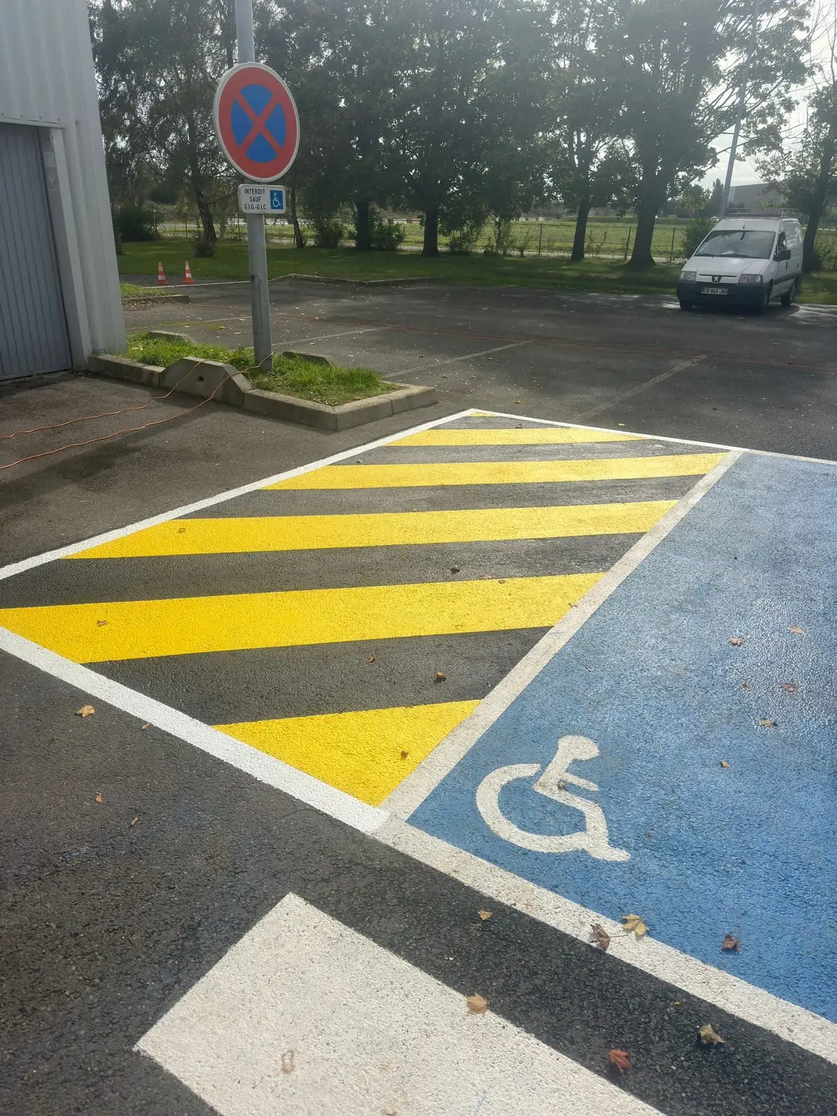 Zébra jaune et place PMR sur l'accès d'un bâtiment tertiaire
