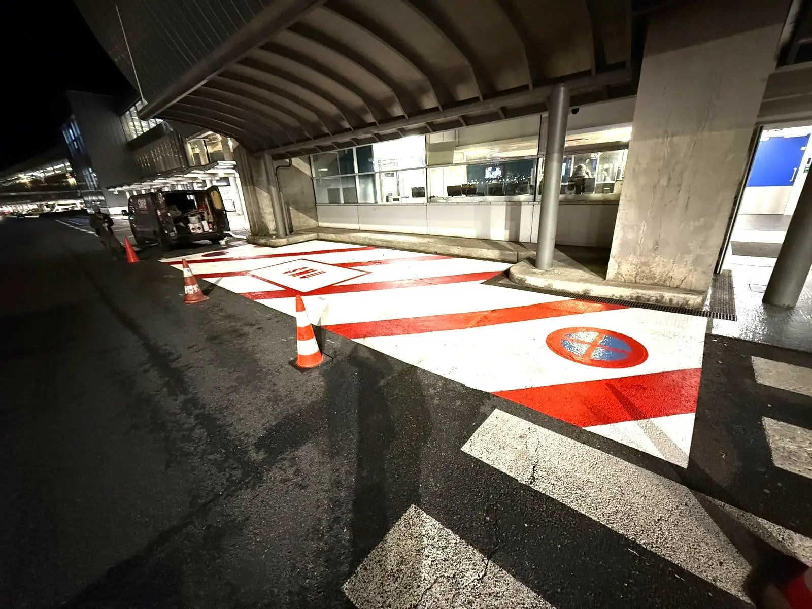 Balisage rouge et blanc d'une zone interdite sur un parvis de centre commercial